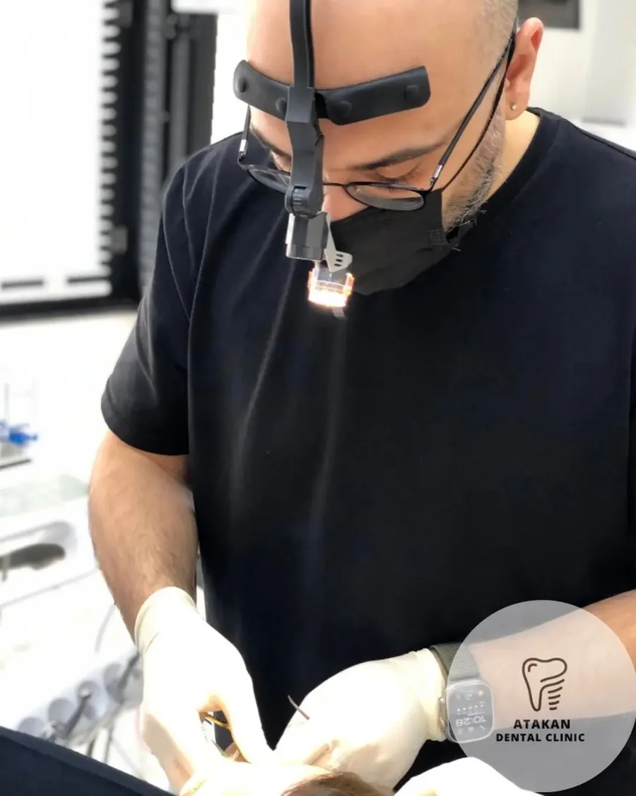 Atakan Dental Clinic hekimi, büyüteçli başlık ve ışık kullanarak tedavi uygularken